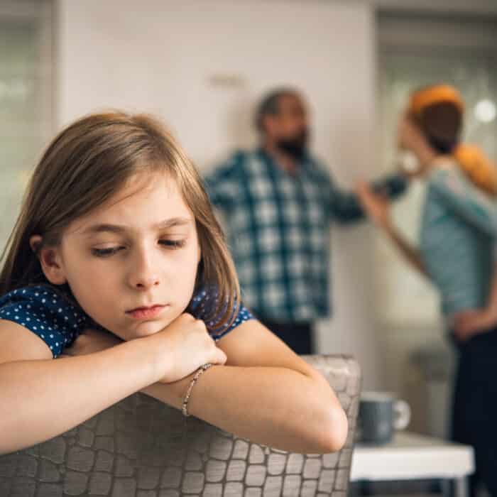 Traumatized daughter listening parents arguing at home